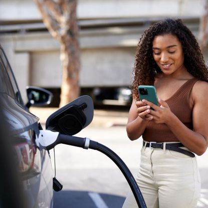 Best plug in hybrid cars for 2023: A woman standing with an electric car